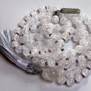 A Himalayan Crackled Quartz Mala Necklace featuring smooth, authentic crackled quartz beads in a clear, textured finish. The necklace is hand-knotted between each bead for durability and is finished with a beautifully crafted tassel. It supports the Crown Chakra, promoting clarity and transformation.