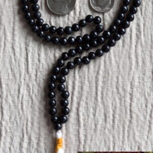 A Black Onyx mala necklace with 108 hand-knotted beads, designed for grounding and protection. Ideal for meditation, featuring smooth, polished onyx beads associated with the Root Chakra and the zodiac signs Capricorn and Leo.