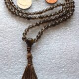 Smokey Quartz Mala Necklace with 108 hand-knotted beads, designed to activate the Root and Solar Plexus Chakras. Resonates with Capricorn and Scorpio, offering grounding, protection, and emotional stability.