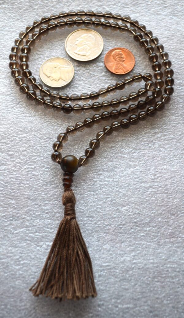 Smokey Quartz Mala Necklace with 108 hand-knotted beads, designed to activate the Root and Solar Plexus Chakras. Resonates with Capricorn and Scorpio, offering grounding, protection, and emotional stability.