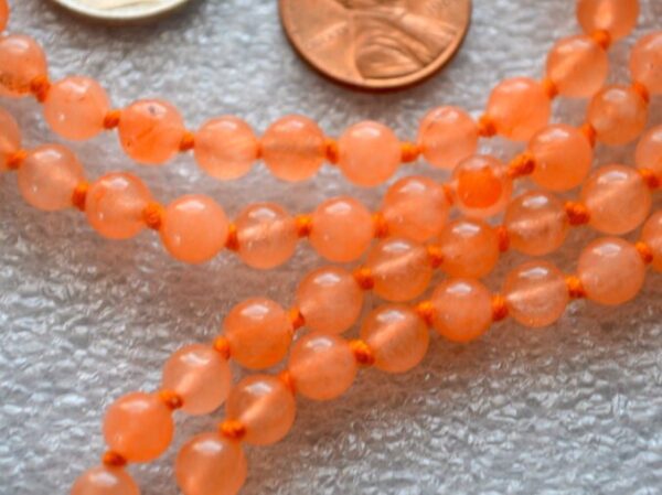 Orange Jade Mala Necklace with 108 hand-knotted beads, designed to activate the Sacral and Solar Plexus Chakras. Ideal for Leo and Sagittarius, boosting creativity and confidence. Perfect for meditation and personal empowerment.