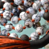 A vibrant Fire Dragon Vein Agate necklace, designed for grounding and courage, featuring fiery patterns on natural stone beads, connected to the Root and Sacral Chakras.