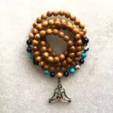 Throat Chakra Balancing Mala Beads Necklace featuring wooden beads, Blue Lace Agate, Aquamarine, and Turquoise, designed for communication enhancement and Throat Chakra support, associated with Aquarius and Pisces zodiac signs.