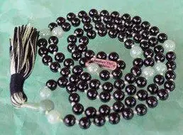 A tactile Black Tourmaline & Aventurine Mala Necklace with 108 smooth beads plus 1 central guru bead. Designed to support the Root and Heart Chakras, it resonates with Capricorn and Virgo, offering protection, prosperity, and emotional healing. Handcrafted for quality and comfort, ideal for meditation.