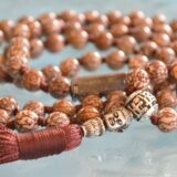 Hand-knotted Bodhi seed mala necklace with star and moon motifs, symbolizing spiritual enlightenment and cosmic connection. Ideal for meditation, featuring 108 beads for Crown Chakra balancing.