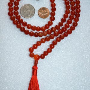 A Carnelian Mala Beads Necklace featuring 108 hand-knotted carnelian beads, designed to enhance creativity and vitality, resonating with the Sacral Chakra and associated with Aries and Leo zodiac signs.