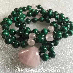 A Rose Quartz & Malachite Mala Necklace featuring smooth, authentic beads in soft pink rose quartz and vibrant green malachite. The necklace is hand-knotted between each bead for durability and finished with a beautifully crafted tassel. It supports the Heart Chakras, promoting love, emotional healing, and transformation.