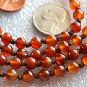 Orange Brown Jade Mala Necklace with 108 beads, brass guru bead, and brown tassel, promoting grounding and creativity.