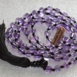 Amethyst Mala Necklace featuring 108 hand-knotted Amethyst beads, designed for spiritual awareness, inner peace, and connection to higher consciousness. Aligns with the Third Eye and Crown Chakras, resonating with Aquarius and Pisces.