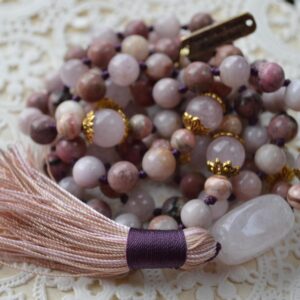 A Kunzite, Rose Quartz, Rhodonite & Rhodochrosite Mala Necklace featuring 108 beads plus 1 guru bead. This necklace supports the Heart Chakra, resonates with Taurus and Libra, and promotes love, compassion, and emotional healing. Hand-knotted and ideal for meditation.