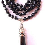 Black Jade Mala Necklace with 108 hand-knotted beads, designed for protection and stability, balancing the Root and Solar Plexus Chakras, resonating with the Taurus and Capricorn zodiac signs.