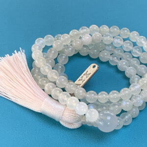 A handcrafted Rainbow Moonstone Mala Necklace with 108 beads, designed to align the Crown and Third Eye chakras, offering balance and emotional healing.