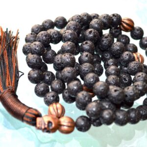 A Skull & Lava Mala Necklace designed for grounding and transformation, featuring 108 hand-knotted beads with a combination of lava and skull beads, resonating with Scorpio and Aries.