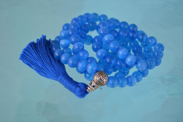 A Blue Cat's Eye Beads Mala Necklace designed for Throat Chakra alignment, resonating with Gemini and Aquarius energies, enhancing communication and mental clarity.