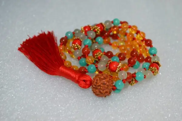 A vibrant Citrine, Coral, Jade, Aventurine, Carnelian, and Rudraksha Mala necklace with 108 beads plus 1 guru bead. Supports the Sacral and Heart Chakras, aligned with Aries and Leo for abundance, vitality, and emotional balance. Handcrafted for meditation and spiritual practice.