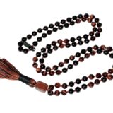 Red Tiger Eye & Tourmaline Mala Necklace featuring 108 hand-knotted beads, designed to promote protection, confidence, and grounding. Ideal for meditation and spiritual practices, aligning with the Root and Solar Plexus Chakras, and resonating with Aries and Capricorn.