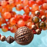 Orange Jade and Agate Mala Necklace featuring 108 hand-knotted beads, designed to activate the Sacral and Solar Plexus Chakras for creativity and vitality, associated with Aries and Leo.