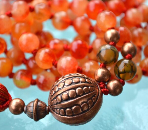 Orange Jade and Agate Mala Necklace featuring 108 hand-knotted beads, designed to activate the Sacral and Solar Plexus Chakras for creativity and vitality, associated with Aries and Leo.