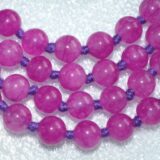 Magenta Agate Knotted Mala Necklace featuring 108 hand-knotted beads, activating the Root and Heart Chakras for strength and balance, associated with Aries and Scorpio.