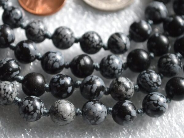 Snowflake Obsidian Mala Necklace featuring 108 hand-knotted beads, designed for grounding and emotional balance. Resonates with Capricorn and Virgo zodiac signs.