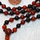 Carnelian & Black Tourmaline Mala Necklace featuring vibrant Carnelian and protective Black Tourmaline beads, designed to support the Root and Sacral Chakras and enhance vitality and protection for Aries and Scorpio zodiac signs.