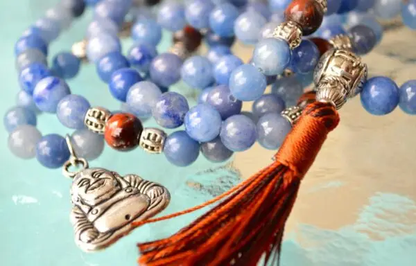 A Blue Aventurine & Buddha Charm Mala Beads Necklace featuring genuine blue aventurine beads, a Buddha charm, and connections to the Third Eye and Throat Chakras, with associations to Libra and Virgo, designed for inner peace and spiritual wisdom.