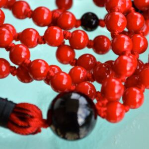 Red Coral & Black Onyx Mala Necklace featuring 108 hand-knotted beads, designed to enhance courage and protection. Ideal for meditation and spiritual practices, aligning with the Root and Sacral Chakras, and resonating with Aries and Capricorn.