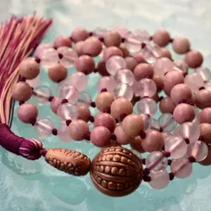 A Rose Quartz & Rhodonite Mala Necklace featuring beads designed to enhance emotional healing, self-love, and balance the Heart Chakra, associated with the zodiac signs Libra and Taurus.