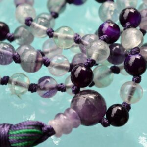 A Rainbow Fluorite Mala Necklace with 108 beads plus 1 guru bead. This necklace supports the Third Eye and Crown Chakras, resonates with Aquarius and Pisces, and enhances intuition and mental clarity. Handcrafted for quality and comfort, ideal for meditation and spiritual practice.