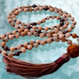 Peach Moonstone & Garnet Mala Necklace featuring 108 hand-knotted beads designed for emotional balance and vitality. Resonates with Cancer and Leo zodiac signs.