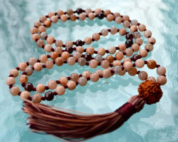 Peach Moonstone & Garnet Mala Necklace featuring 108 hand-knotted beads designed for emotional balance and vitality. Resonates with Cancer and Leo zodiac signs.