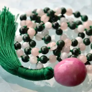 A Rose Quartz, Moonstone, and Malachite Mala Necklace featuring 108 beads plus 1 guru bead. This necklace supports the Heart and Third Eye Chakras, resonating with Taurus and Cancer, promoting love, intuition, and transformation. Handcrafted, it’s ideal for meditation and spiritual practice.