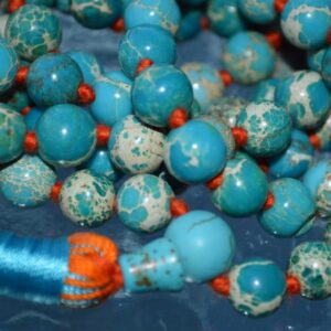 A Turquoise Sea Sediment Mala Necklace featuring natural turquoise beads, hand-knotted for durability, promoting communication and emotional healing, aligned with Throat and Heart Chakras, ideal for Sagittarius and Pisces zodiac signs.