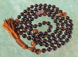 Tourmaline & Tiger Eye Mala Necklace with 108 hand-knotted beads, designed to balance the Root and Solar Plexus Chakras. Offers protection and confidence, ideal for Capricorn and Leo.