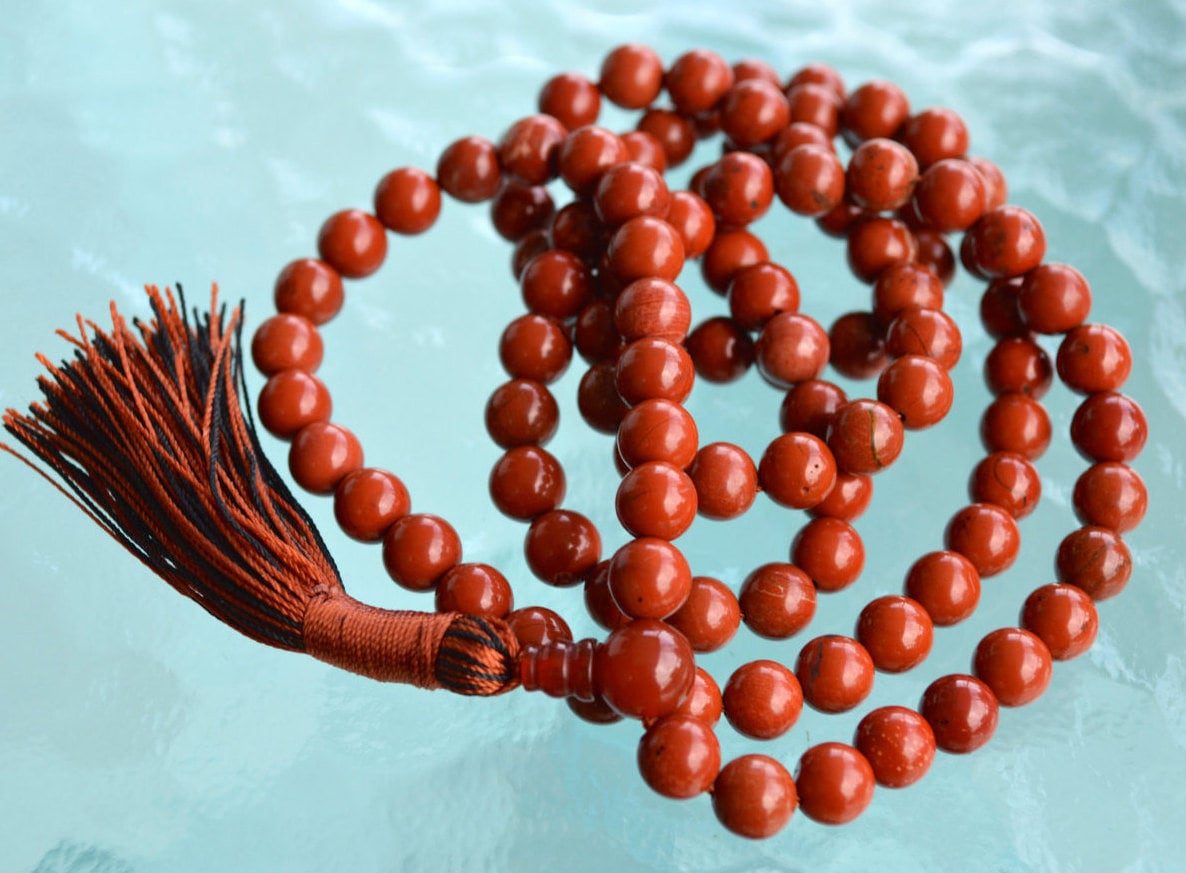 Red Jasper Necklace with 108 hand-knotted beads, designed to activate the Root Chakra. Ideal for Aries and Scorpio, promoting grounding, stability, and courage. Perfect for meditation and spiritual growth.