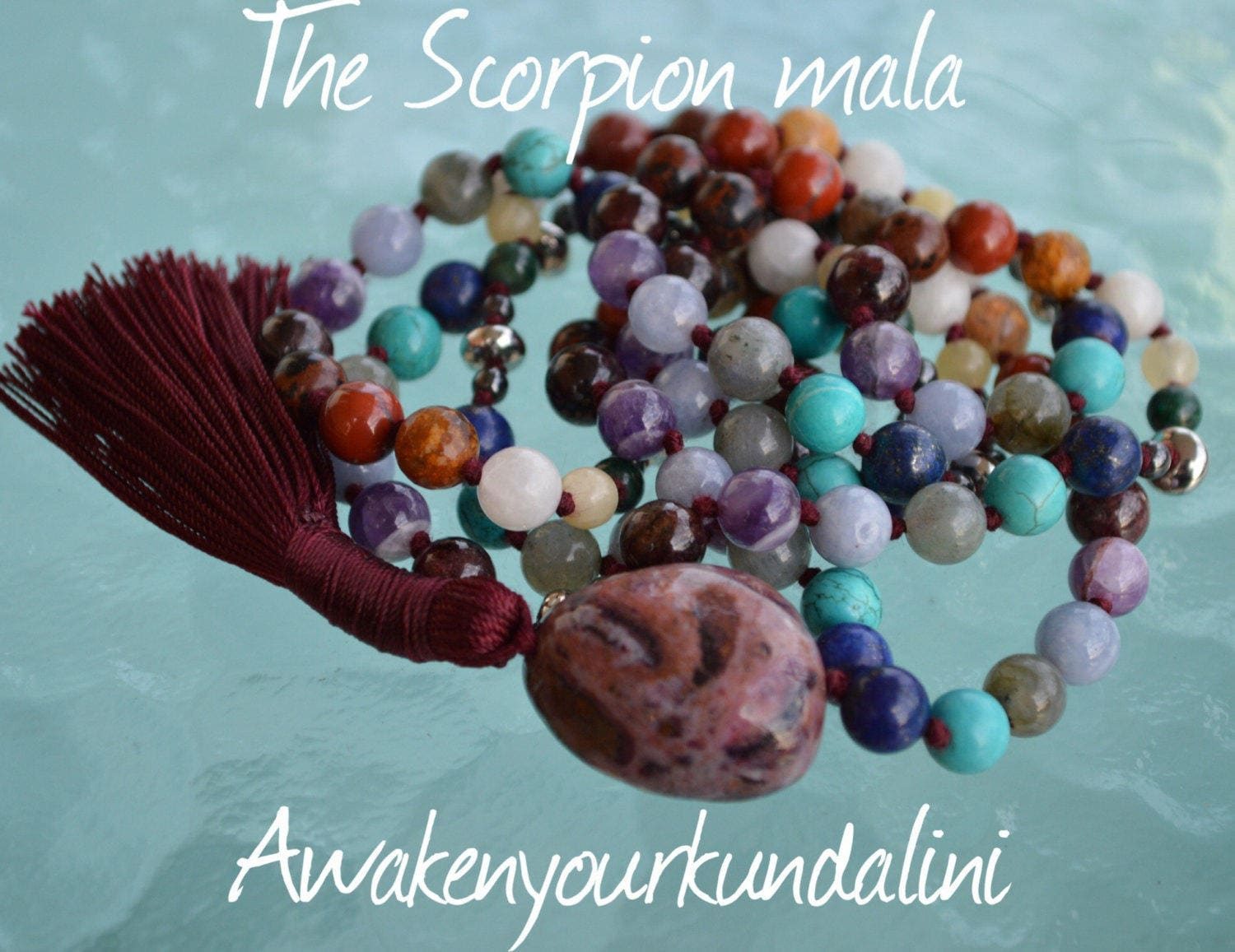 A striking Scorpio mala with red thread, featuring gemstones like Malachite, Jasper, Agate, Hematite, and more, symbolizing transformation, protection, and spiritual growth.