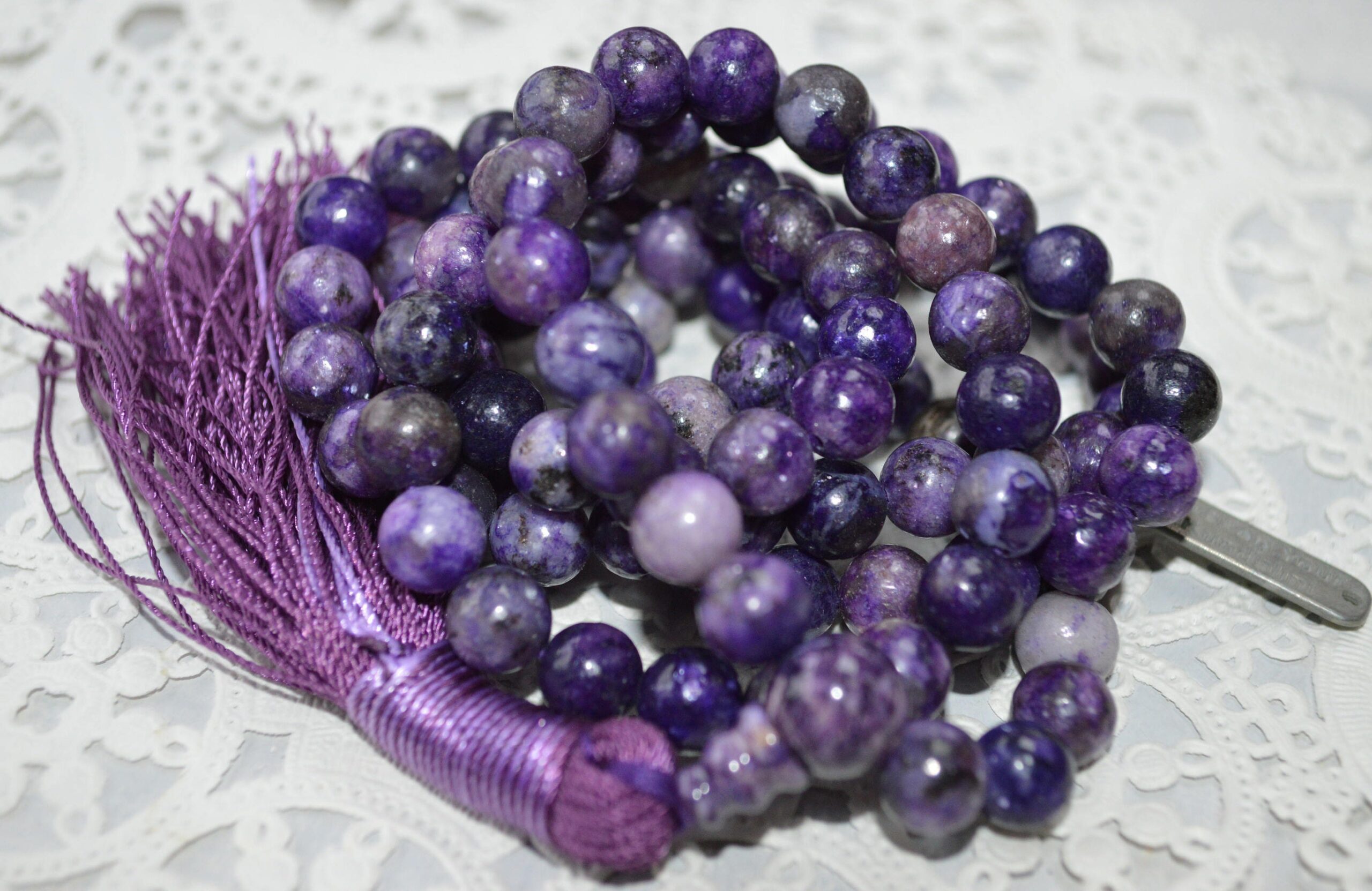 Charoite Mala Necklace with 108 beads, purple guru bead, and tassel, symbolizing transformation and spiritual insight.