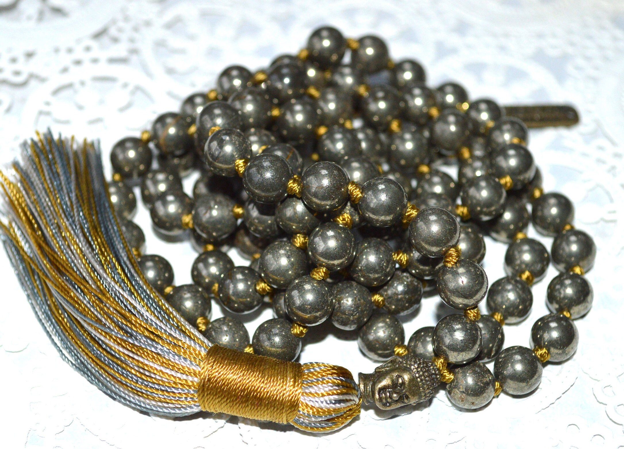 Buddha Pyrite Knotted Mala Necklace designed to enhance the Solar Plexus Chakra, boosting confidence and providing protection, resonates with Leo and Sagittarius for leadership and empowerment.