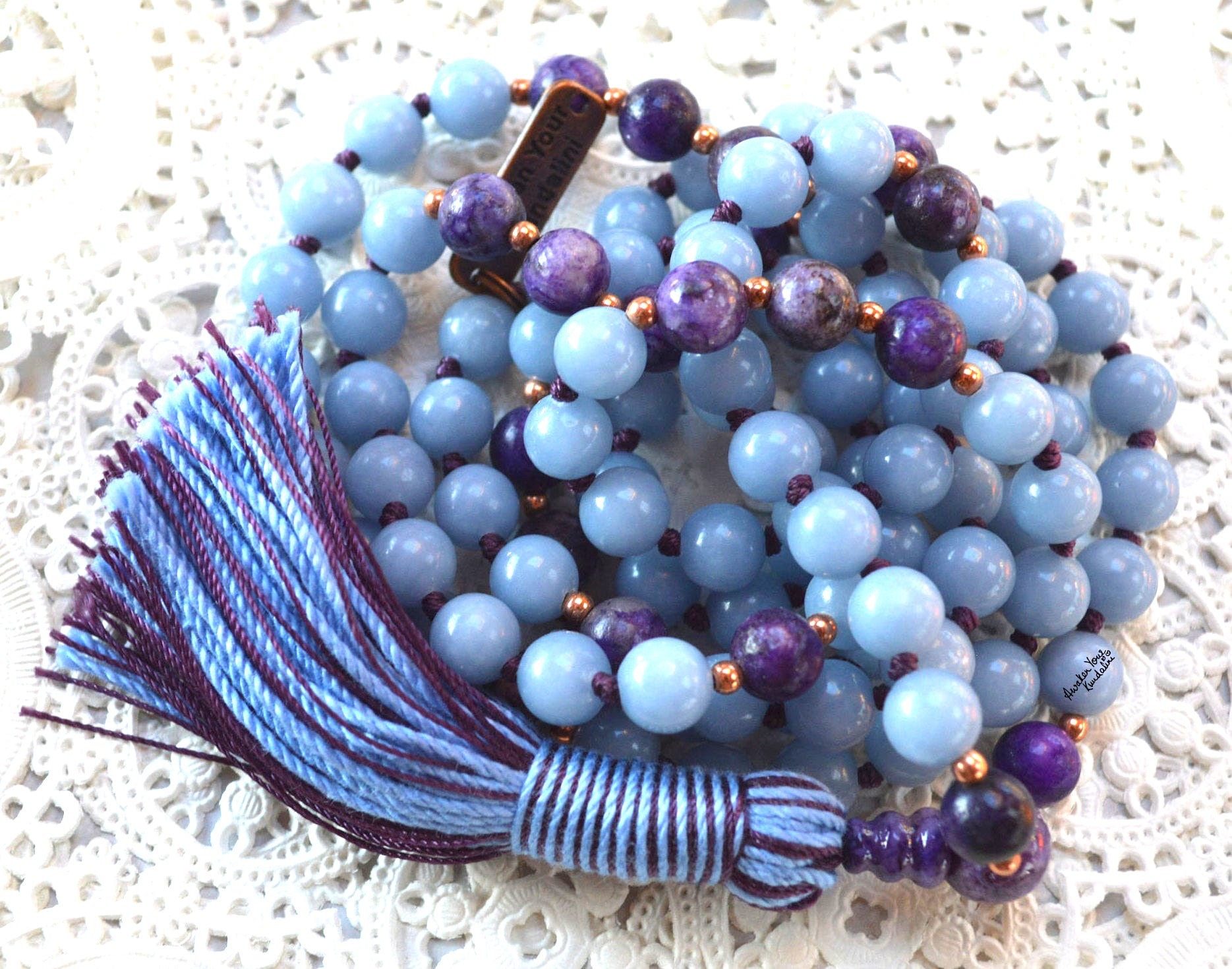 A Charoite & Angelite Mala Necklace with 108 hand-knotted beads designed to activate the Third Eye and Crown Chakras, promoting spiritual awareness and calm. Ideal for meditation, this necklace resonates with Pisces and Aquarius, offering spiritual growth and emotional tranquility.