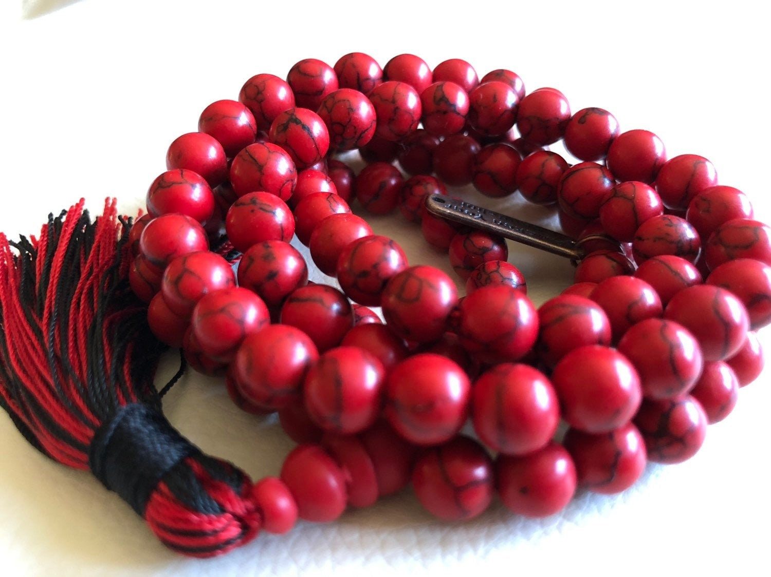 Red Howlite Mala Necklace featuring 108 hand-knotted Red Howlite beads, designed for calming and grounding energy. Aligns with the Root Chakra and resonates with Aries and Scorpio. Ideal for meditation and stress relief.