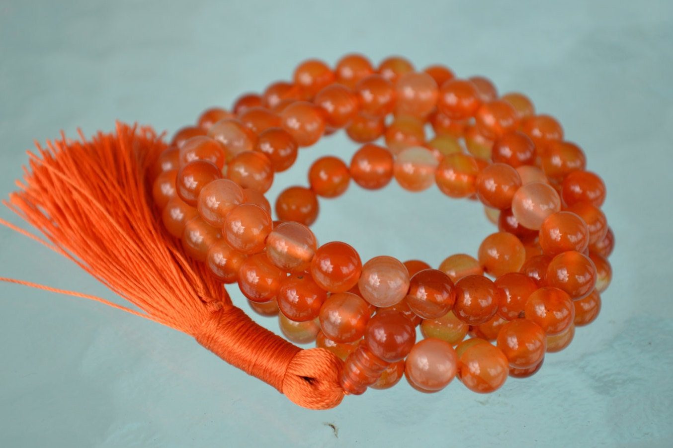 Handcrafted Carnelian Mala Necklace with 108 vibrant orange beads, designed to enhance courage, motivation, and creativity, aligned with the Root and Sacral Chakra