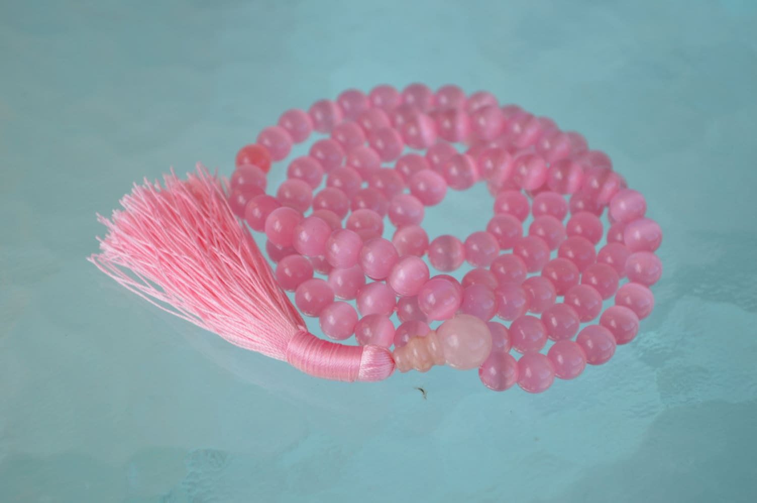 A Pink Cat's Eye Mala Necklace designed for Heart Chakra alignment, resonating with Taurus and Libra energies, enhancing love and emotional healing.