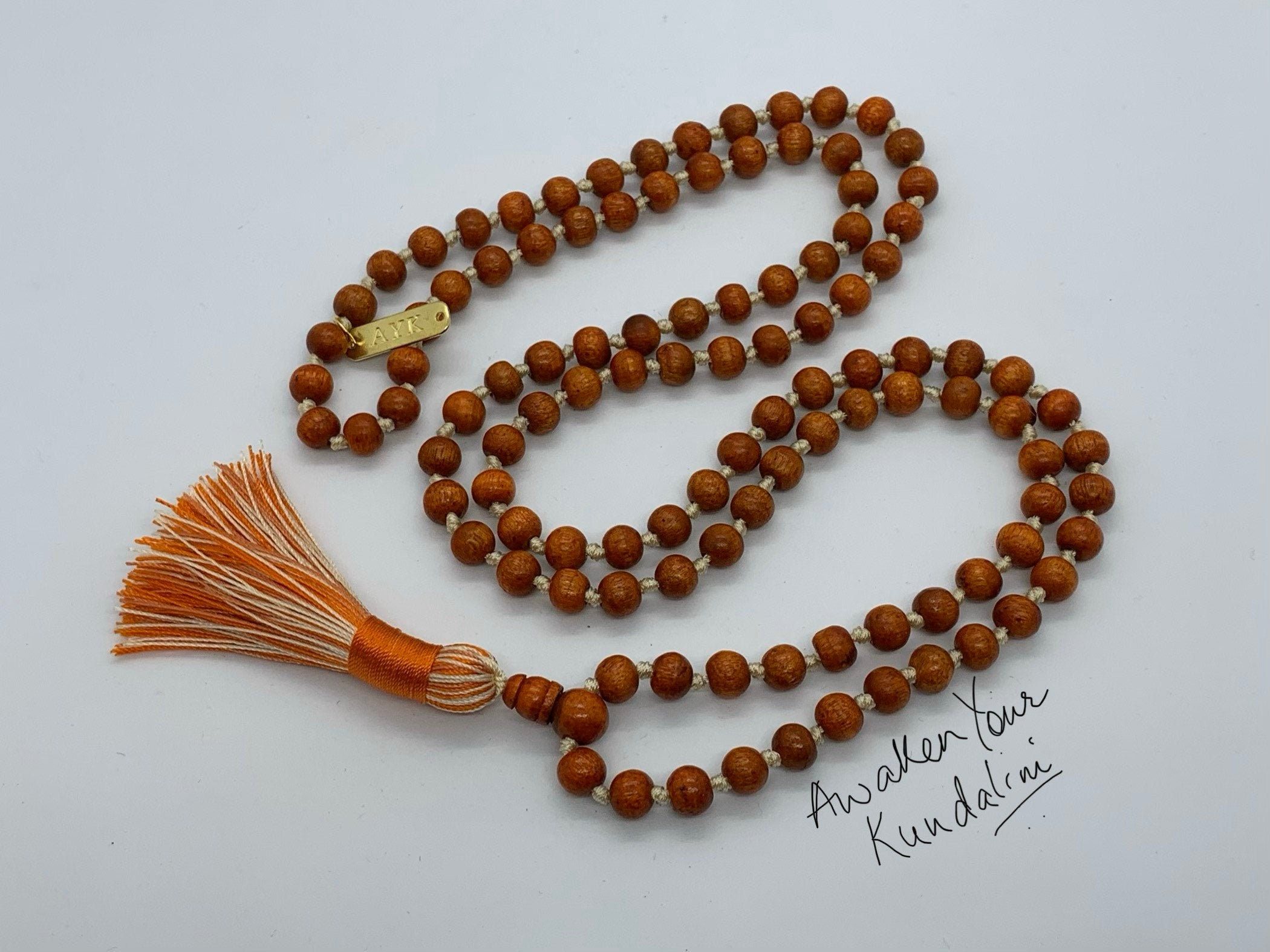 Orange Tulsi Mala Beads Necklace with 108 hand-knotted beads, designed to activate the Heart and Sacral Chakras. Resonates with Leo and Pisces, promoting balance, vitality, and spiritual purity.