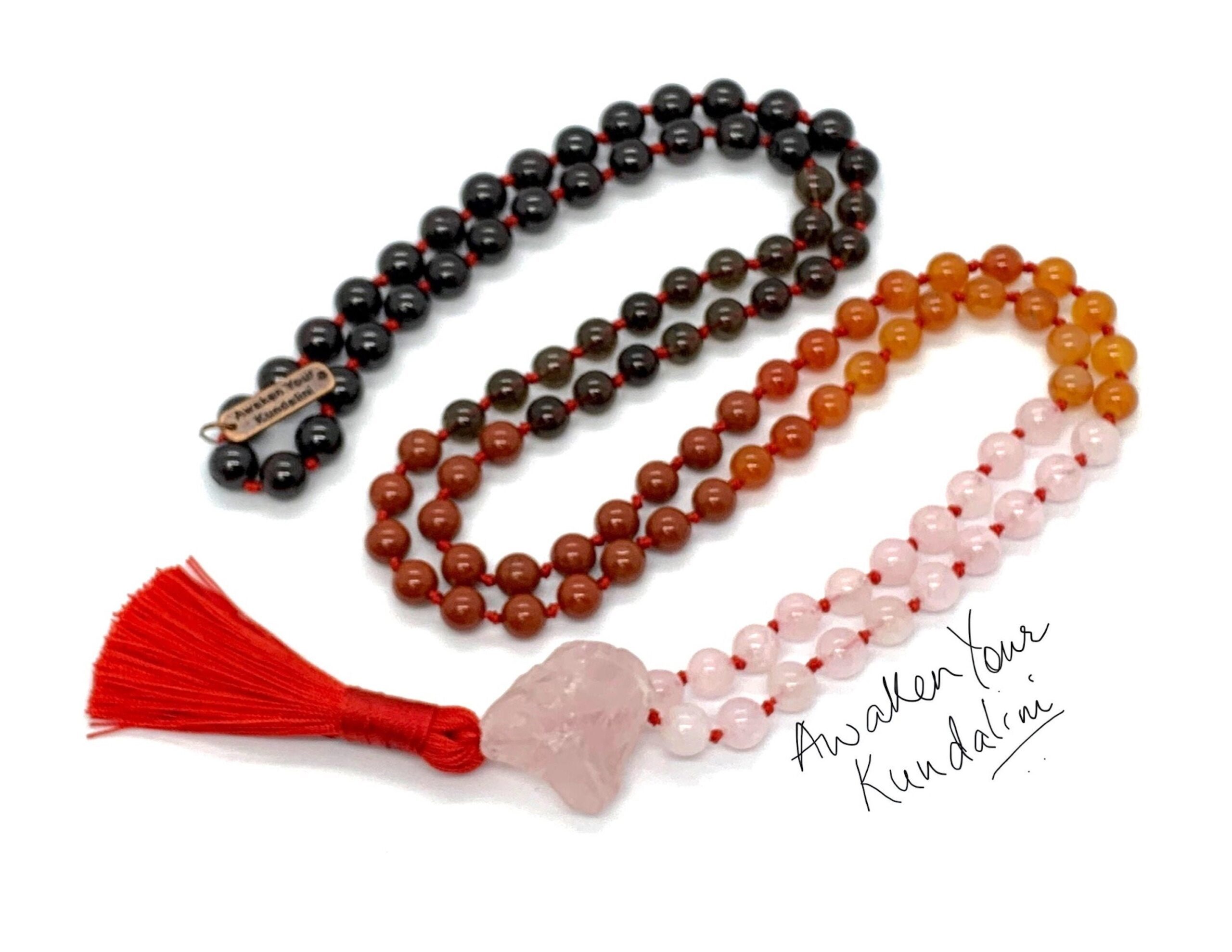 A Red Jasper, Garnet, Smoky Quartz, Rose Quartz, Carnelian Mala Beads Necklace with 108 beads plus 1 guru bead. This necklace supports the Root and Heart Chakras, resonates with Aries and Scorpio, and promotes vitality and emotional healing. Handcrafted for quality and comfort, suitable for meditation and spiritual practice.