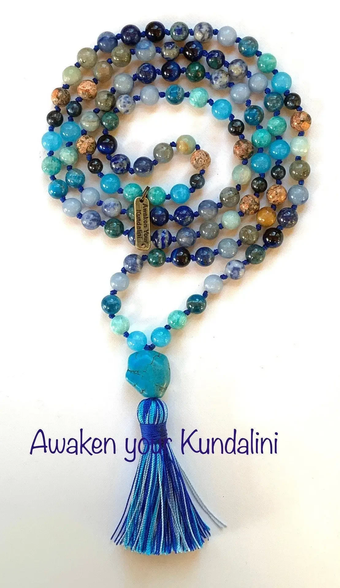 A Blue Throat Chakra Balancing Mala Necklace with Aquamarine, Lapis Lazuli, Labradorite, Amazonite, Chrysocolla, Ocean Jasper, Blue Tiger Eye, Sodalite, Turquoise, and Aventurine. Includes 108 beads plus 1 guru bead. Handcrafted in the USA for meditation and clarity.