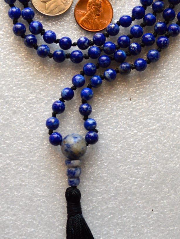 A Lapis Lazuli Mala Necklace featuring 108 beads plus 1 guru bead. This necklace supports the Third Eye and Throat Chakras, resonates with Sagittarius and Libra, and enhances intuition, clarity, and communication. Handcrafted for quality and comfort, suitable for meditation and spiritual practice.