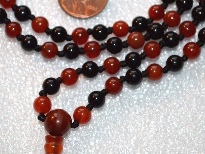 Carnelian & Black Tourmaline Mala Necklace featuring vibrant Carnelian and protective Black Tourmaline beads, designed to support the Root and Sacral Chakras and enhance vitality and protection for Aries and Scorpio zodiac signs.