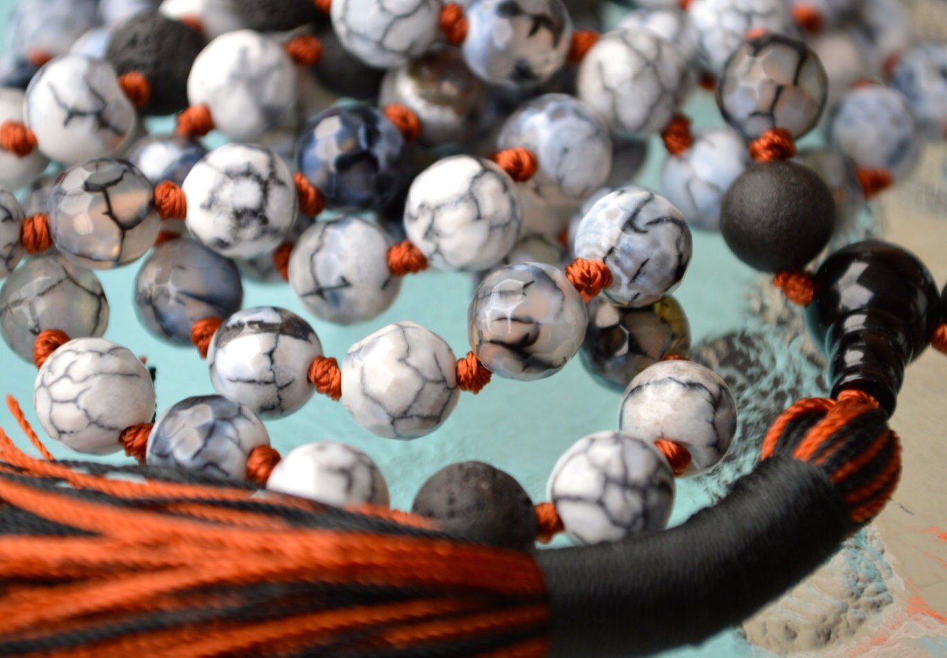 A vibrant Fire Dragon Vein Agate necklace, designed for grounding and courage, featuring fiery patterns on natural stone beads, connected to the Root and Sacral Chakras.