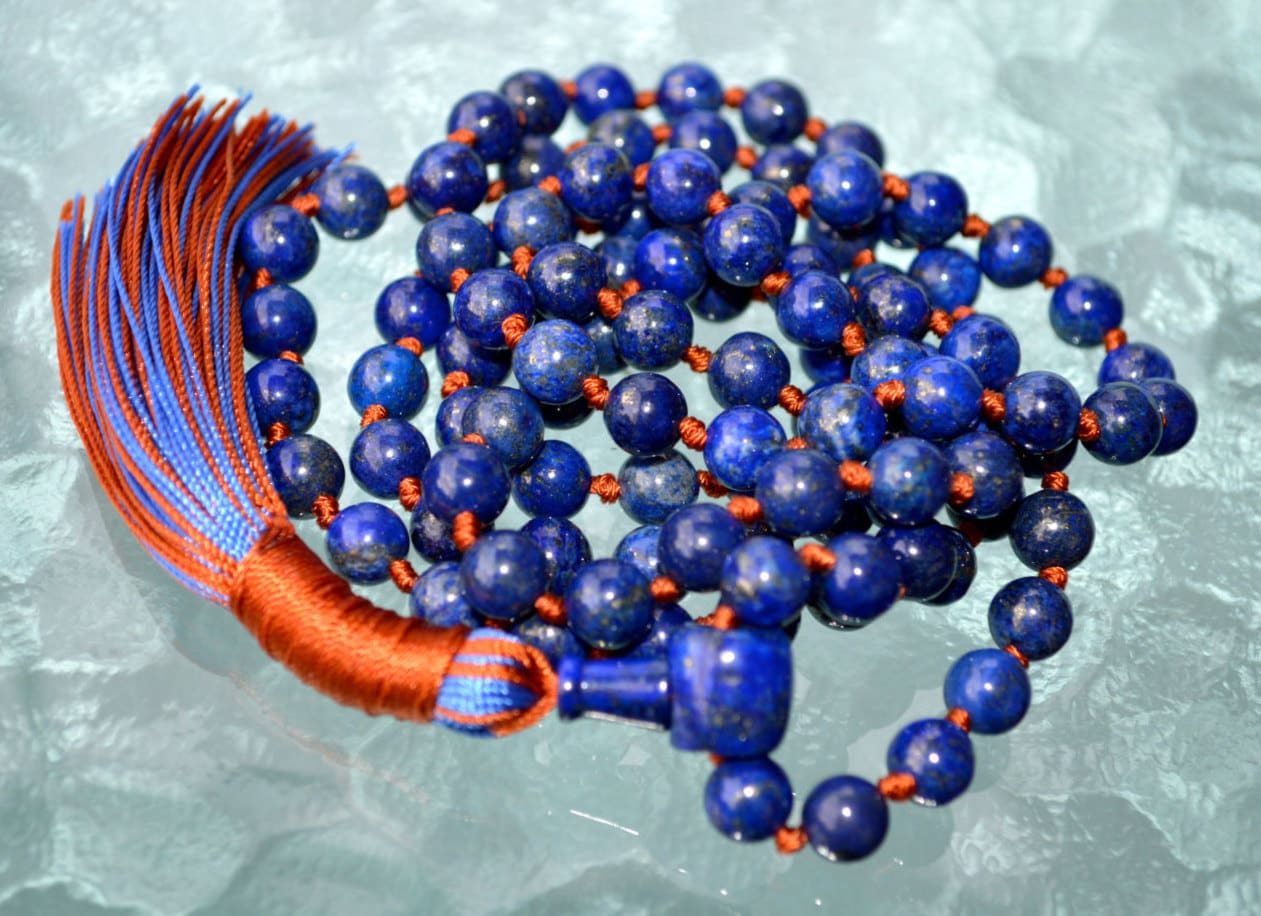 A Lapis Lazuli Mala Necklace featuring 108 beads plus 1 guru bead. This necklace supports the Third Eye and Throat Chakras, aligns with Sagittarius and Libra, and enhances intuition, communication, and self-expression. Handcrafted for quality and comfort, it's ideal for meditation and spiritual practice.