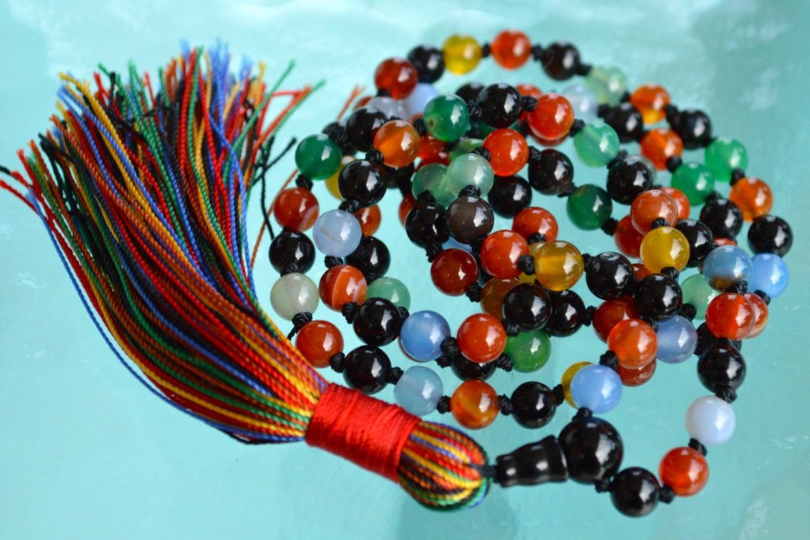 9 Planets Navratan Hand Knotted Beads Necklace, designed to balance the Root and Crown Chakras, resonating with Leo and Capricorn, representing the cosmic energies of the nine planets, perfect for spiritual growth and alignment.